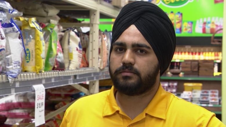 A man in a black turban and yellow shirt.